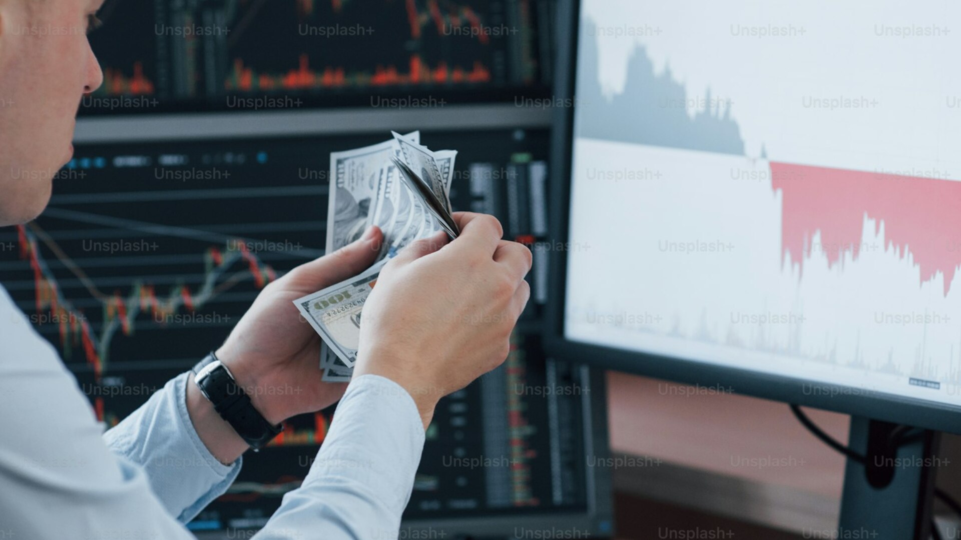 Investor monitoring diversified index charts across multiple monitors