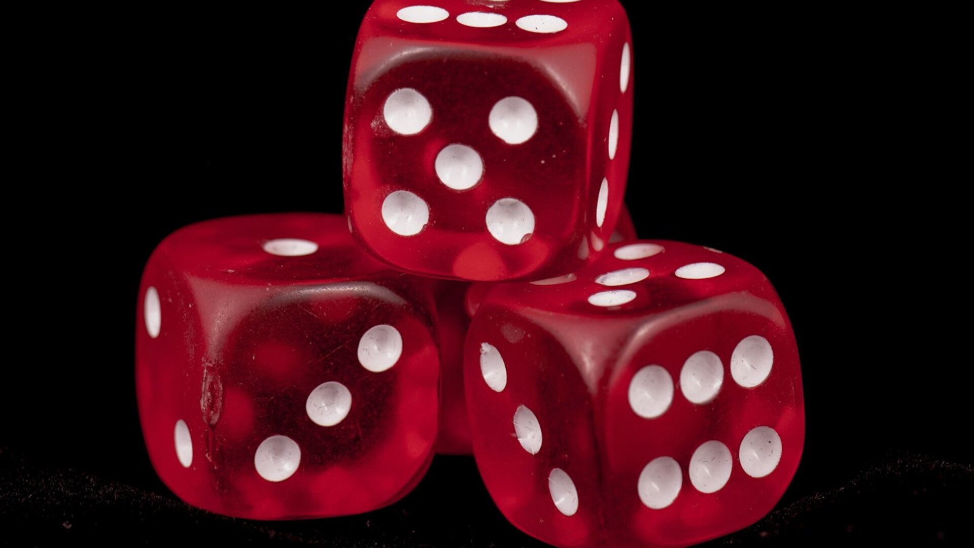 Three crimson dice tumbling across a reflective surface, symbolizing intertwined luck and risk